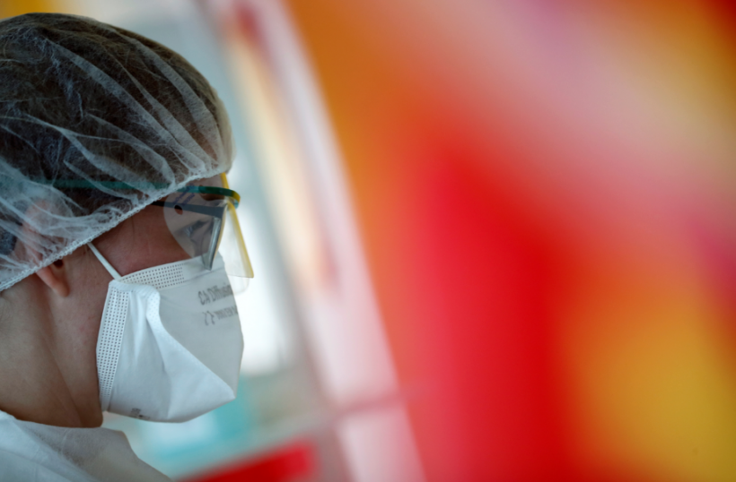 A medical worker, wearing a protective face mask and a protective suit, works in a pulmonology unit at the hospital in Vannes
