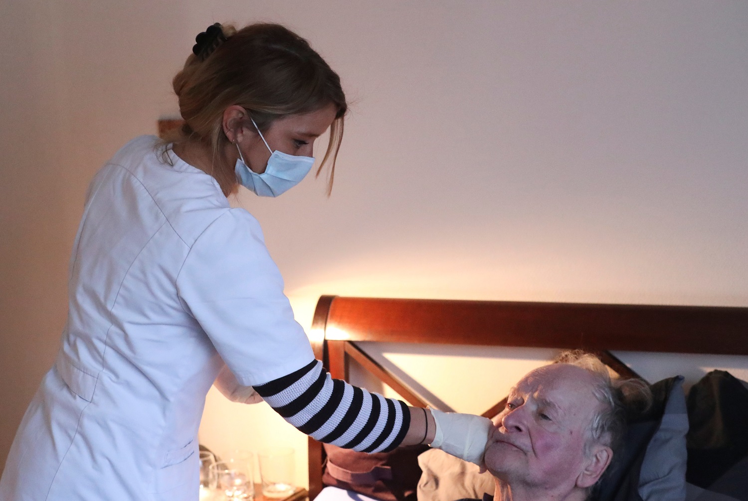 Belgian home nurse Laura Angeli takes care of her patient Arthur Daper at his home in Brussels during the coronavirus lockdown in Belgium