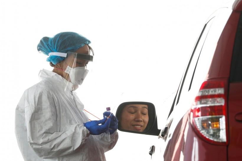 Medical personnel work at a coronavirus (COVID-19) disease drive-thru testing site at George Washington University in Washington