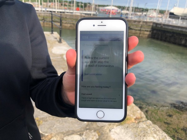 UK National Health Service employee Anni Adams shows a smartphone displaying the new NHS app to trace contacts with people potentially infected with the coronavirus disease (COVID-19) being trialled on Isle of Wight