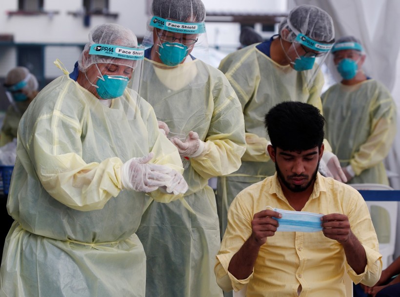 Medical workers prepare to perform a nose swab on a migrant worker at a dormitory, amid the coronavirus disease (COVID-19) outbreak in Singapore