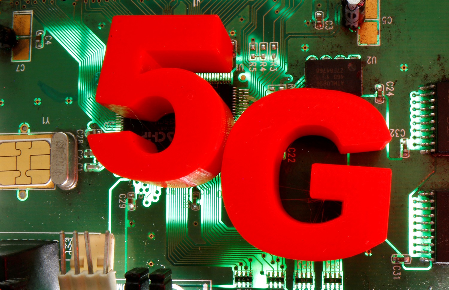  3D-printed objects representing 5G are put on a motherboard in this picture illustration