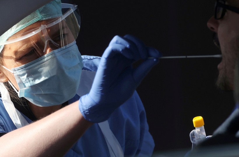A member of medical staff takes a swab from a person in a car at an NHS coronavirus disease (COVID-19) testing facility in Wolverhampton