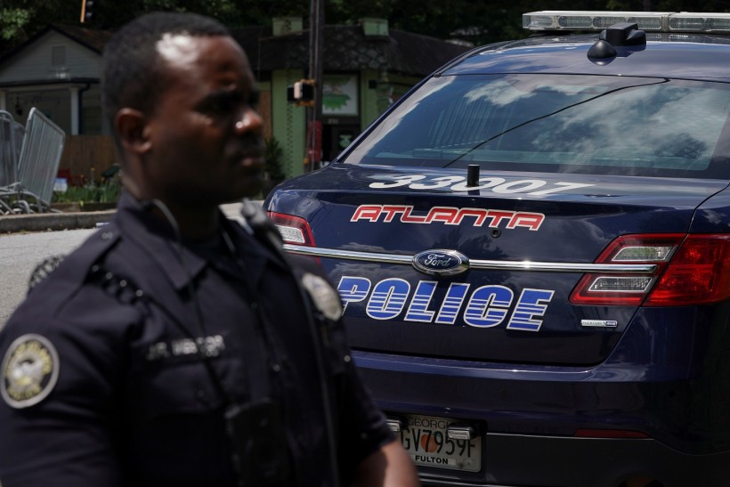 An Atlanta Police Department officer is seen in front of his vehicle in Atlanta
