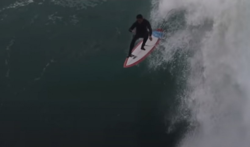 A surfer riding a huge wall of water