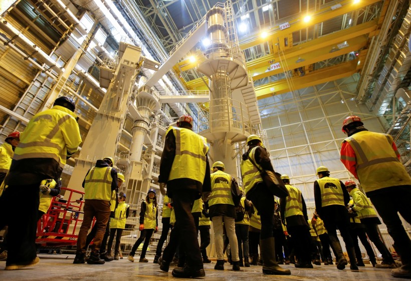 Technicians and visitors stand inside the International Thermonuclear Experimental Reactor (ITER) assembly hall in Saint-Paul-lez-Durance