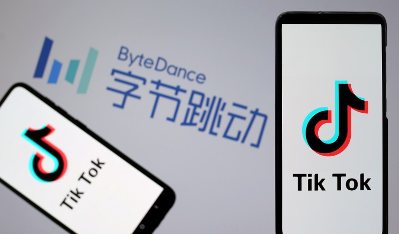 TikTok logos are seen on smartphones in front of displayed ByteDance logo in this illustration