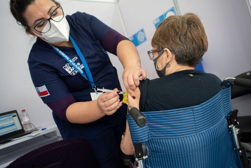 A health worker administers a COVID-19 vaccine to a senior citizen at Estadio Bicentenario de la Florida vaccination centre