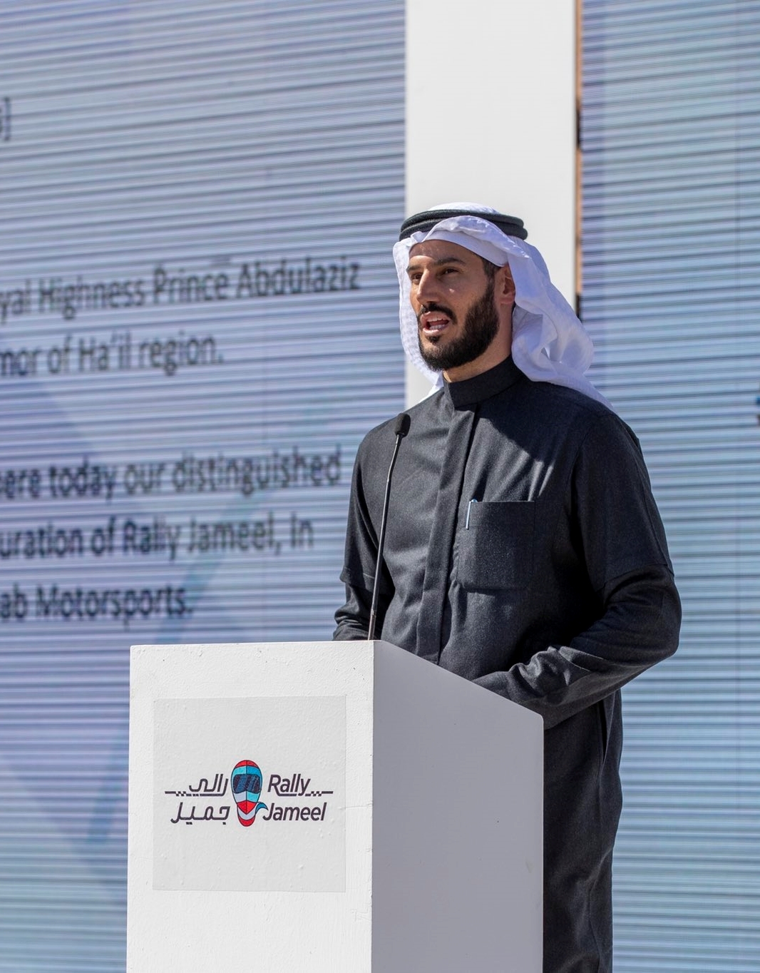 Hassan Jameel speaking at a podium during an ALJ motorsport event