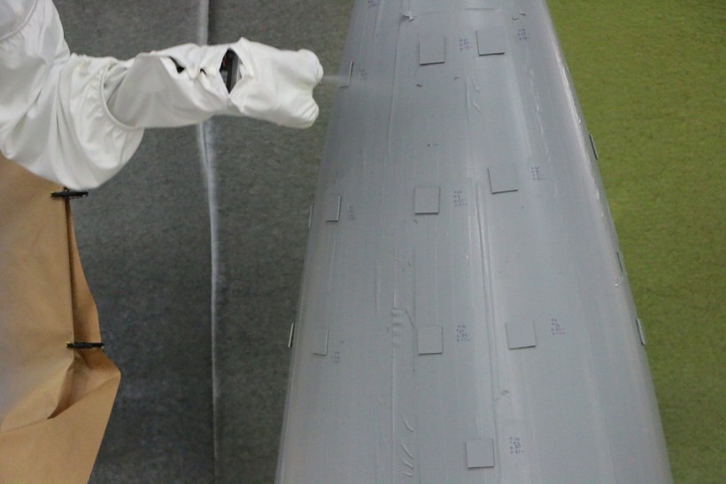 An Aerobotix robotic painting system sprays topcoat onto an aircraft panel