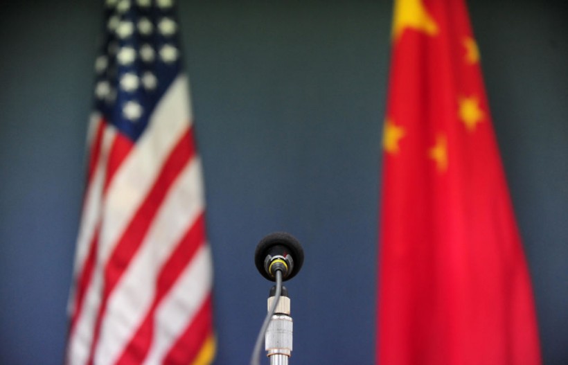 The US and China flags stand behind a mic