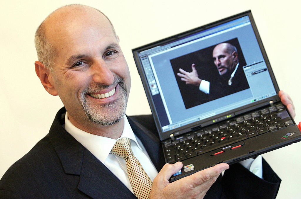 Bruce Chizen, CEO of Adobe Systems, hold