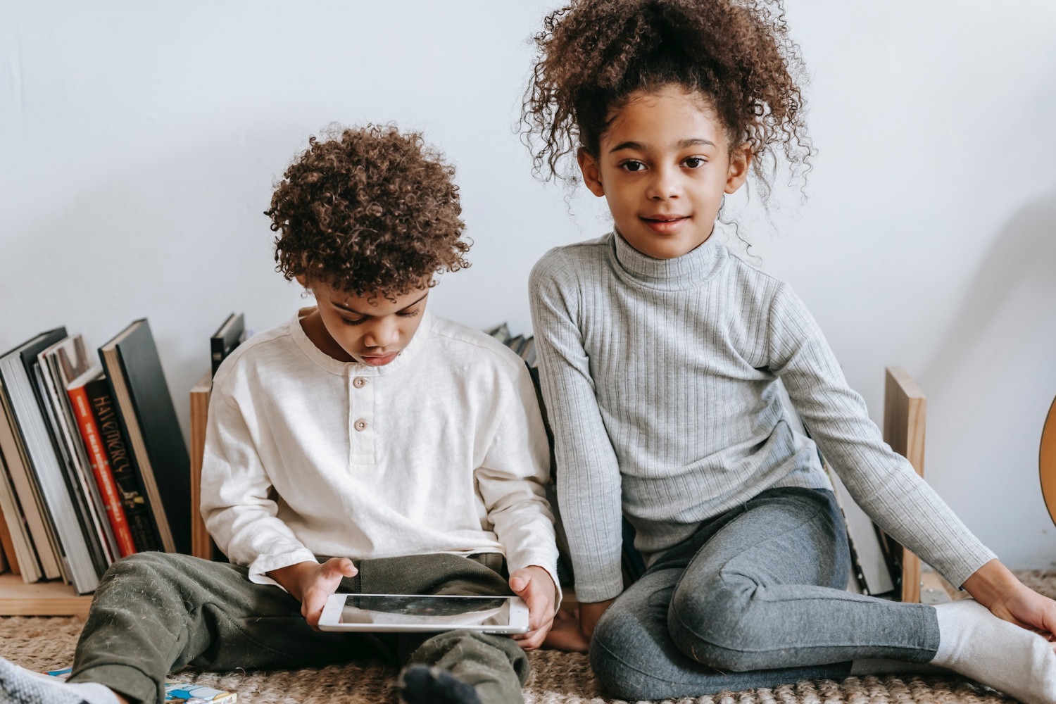 Cheerful black girl with brother browsing tablet