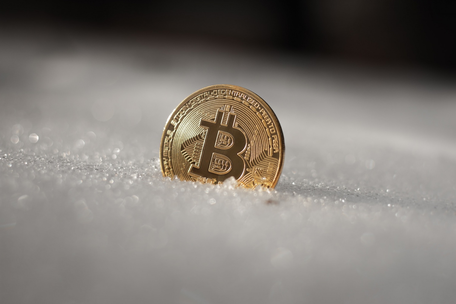 a bit coin sitting on top of snow covered ground