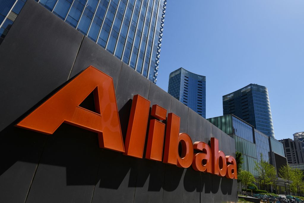 The image shows the logo of Alibaba, a Chinese multinational technology company. The company's name is written in orange letters, and the logo is placed on a black background. The image is set against a backdrop of a modern city. The search query is about the AMD MI309 chip performance and US export restrictions.