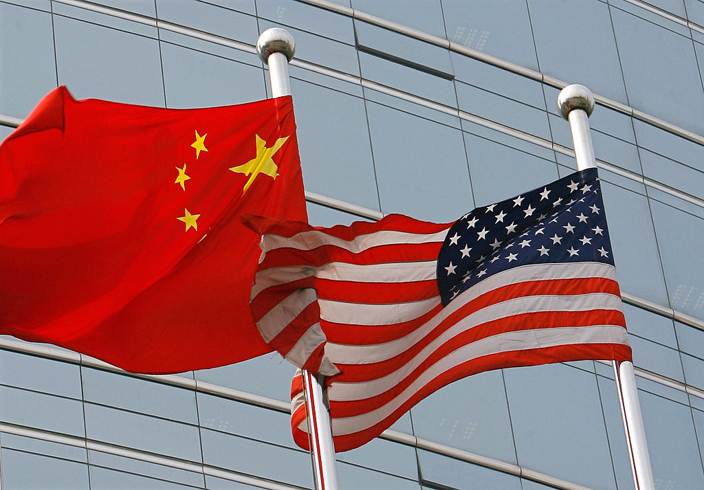 A US and a Chinese flag wave outside a c...