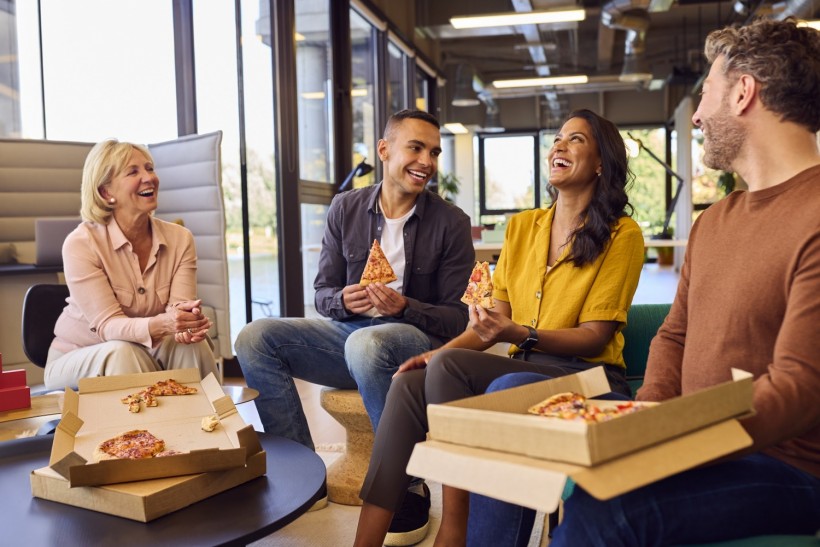 staff at informal meeting in office with takeaway