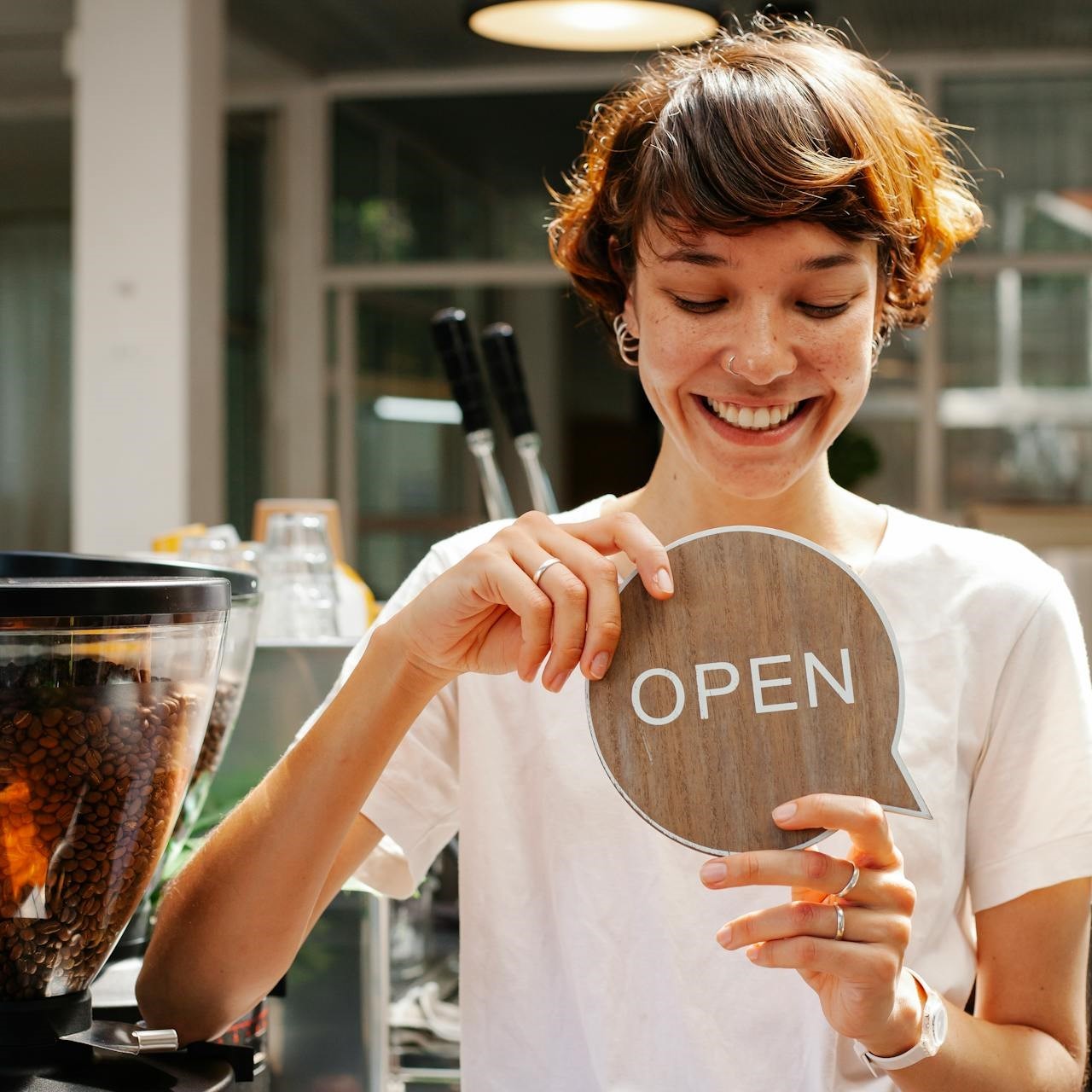 Woman standing in cafe with open sign