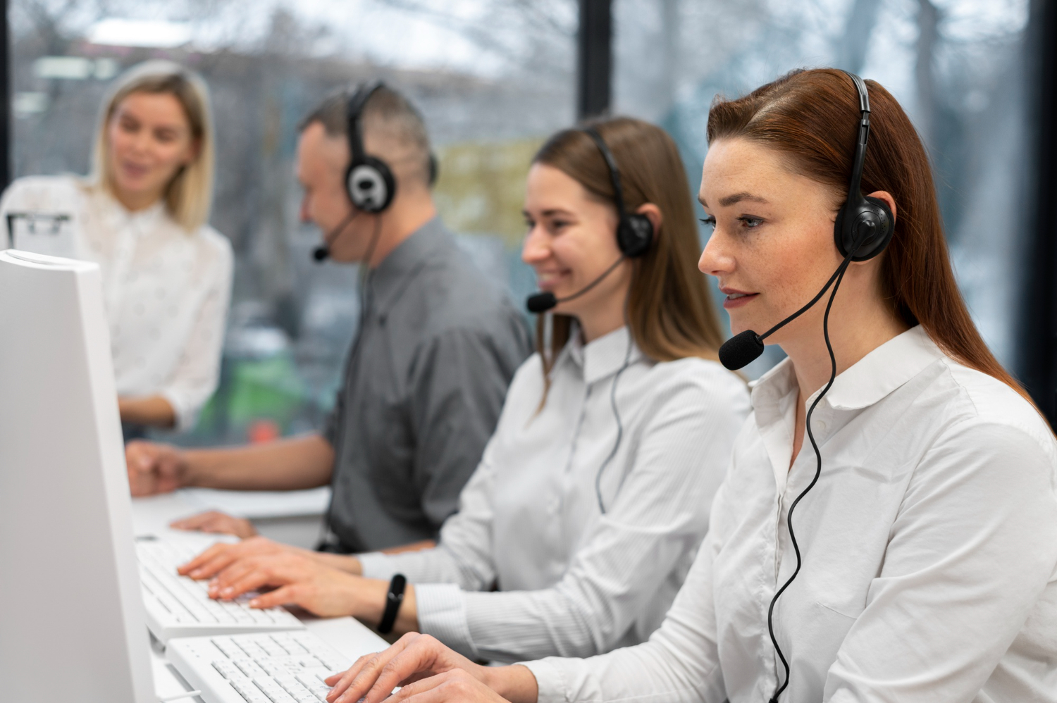 Colleagues working together in a call center with headphones