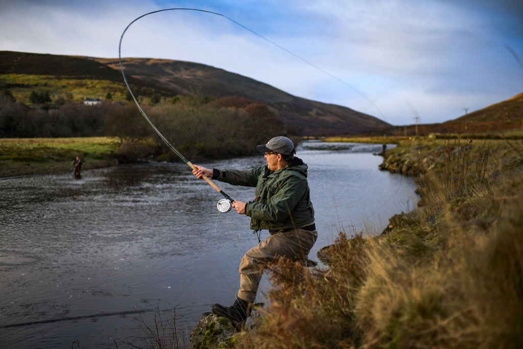 An angler fishes at the opening Of The Salmon Fishing Season